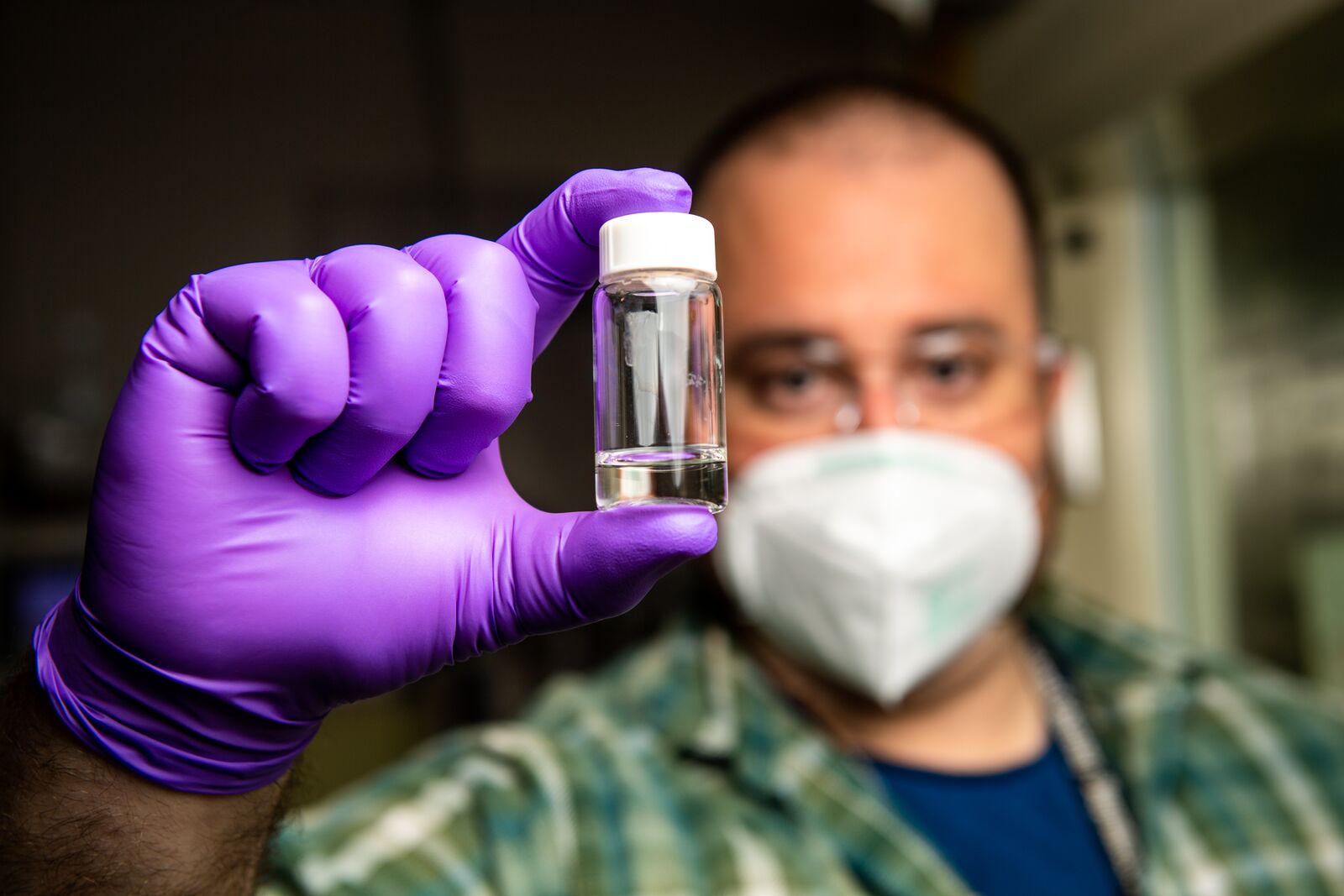 A scientist holds a vial of purified water