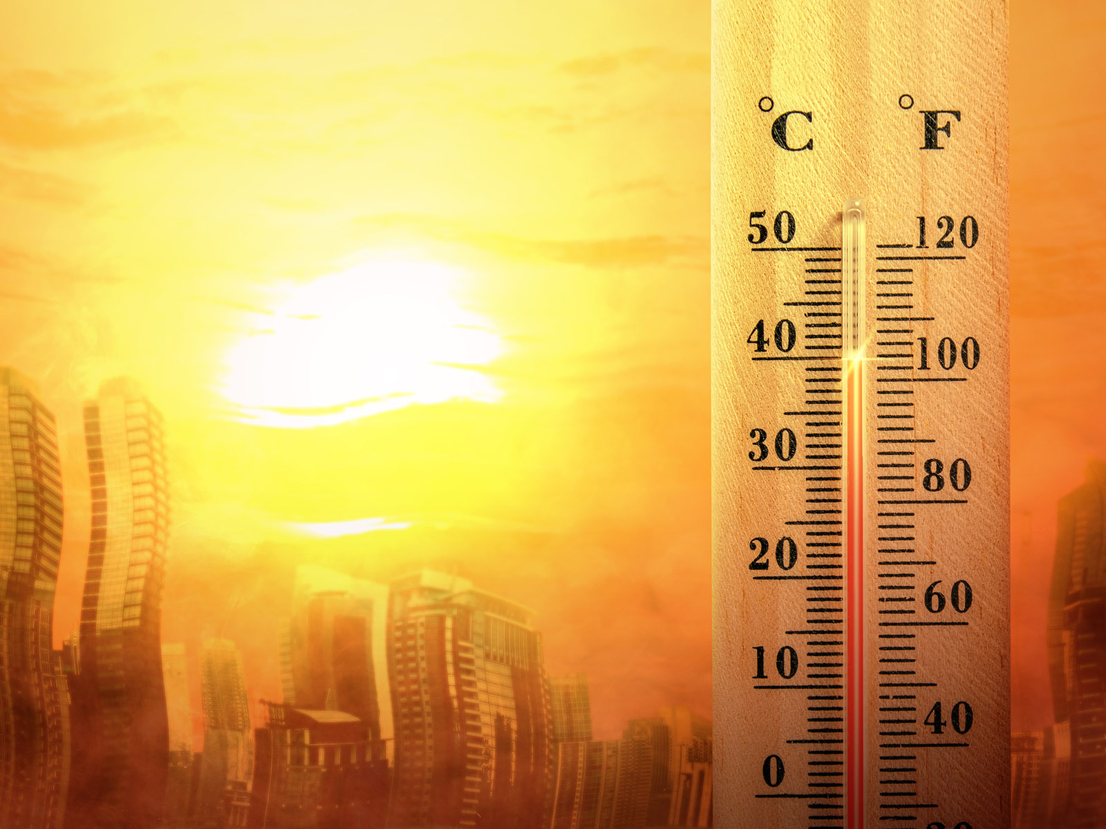 Image shows a thermometer and very warm buildings, to illustrate rising temperatures.