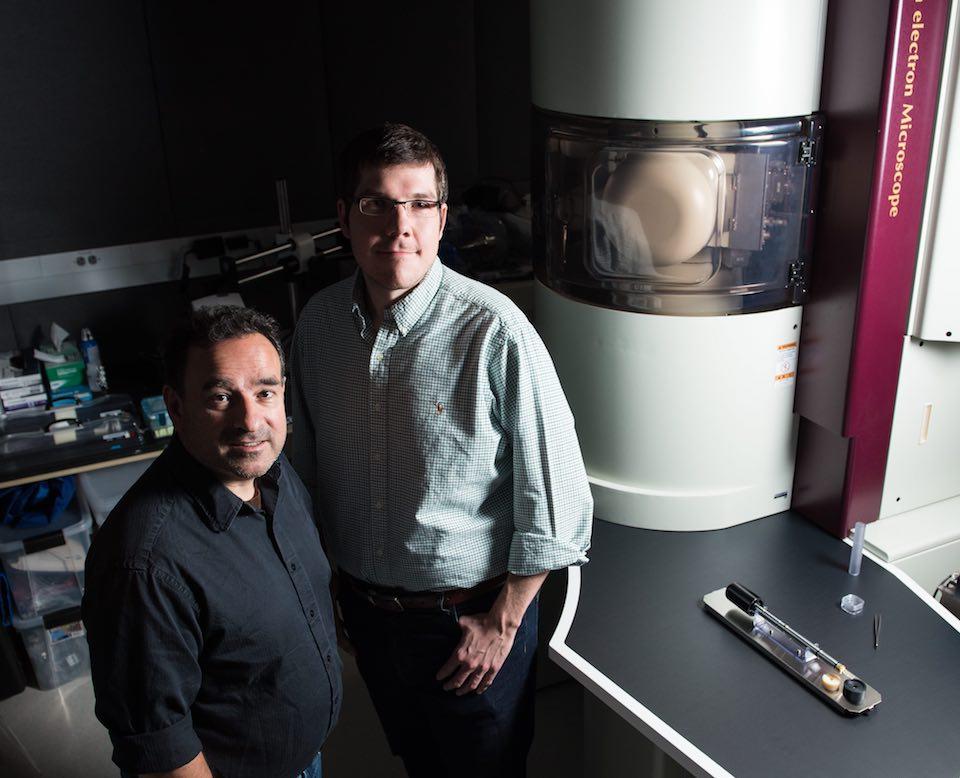 Researchers Edgar Buck and Steven Spurgeon use a huge microscope for nuclear science.
