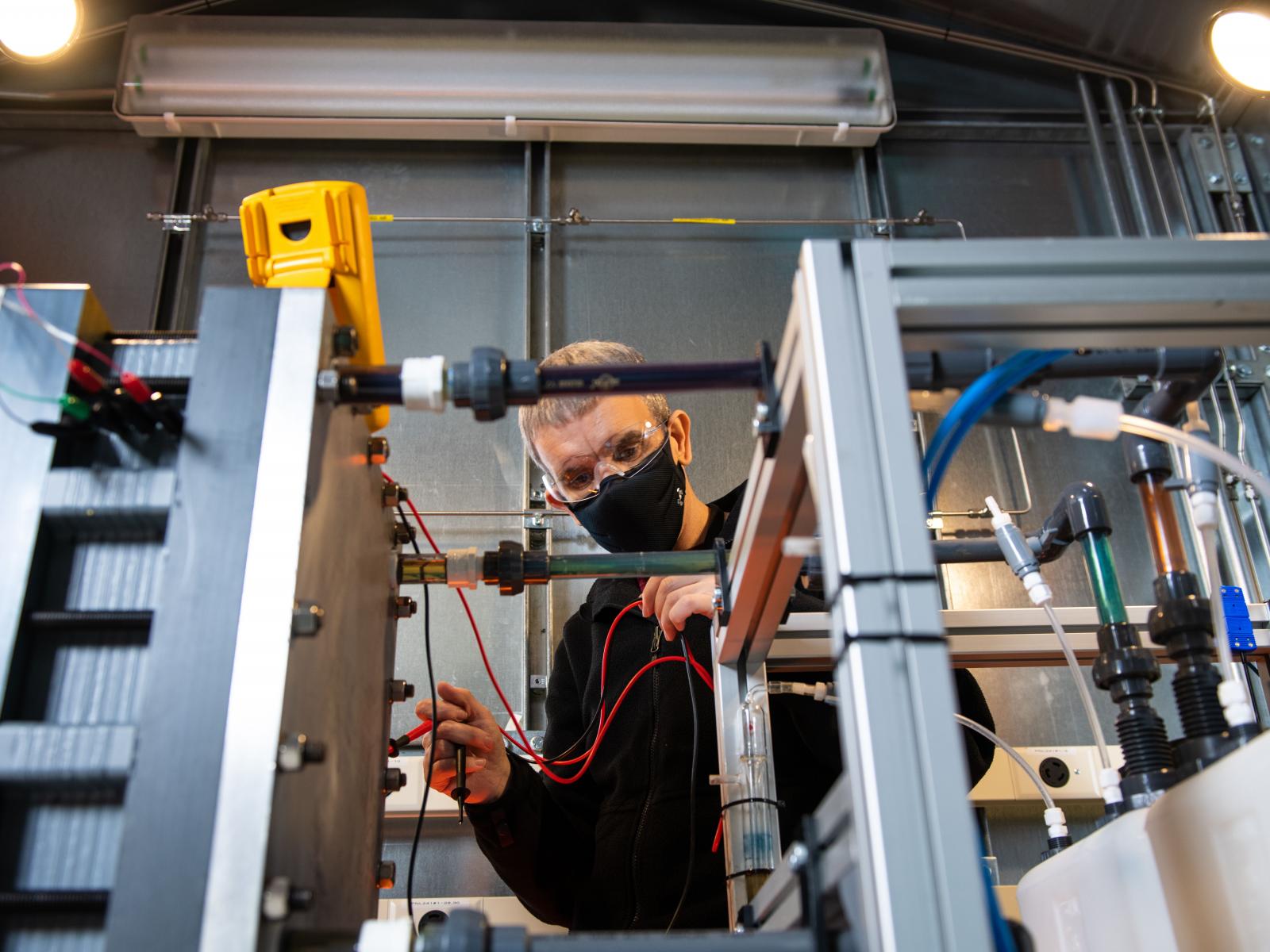 Picture of a scientist working on a flow battery design in one of PNNL’s prototyping labs.