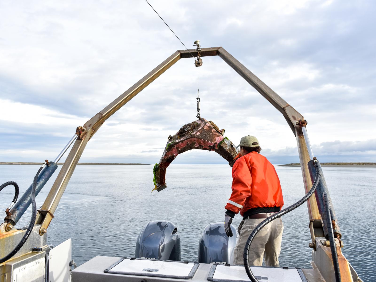 A researcher deploys scientific equipment from the RV Strait Science using the A-frame. 