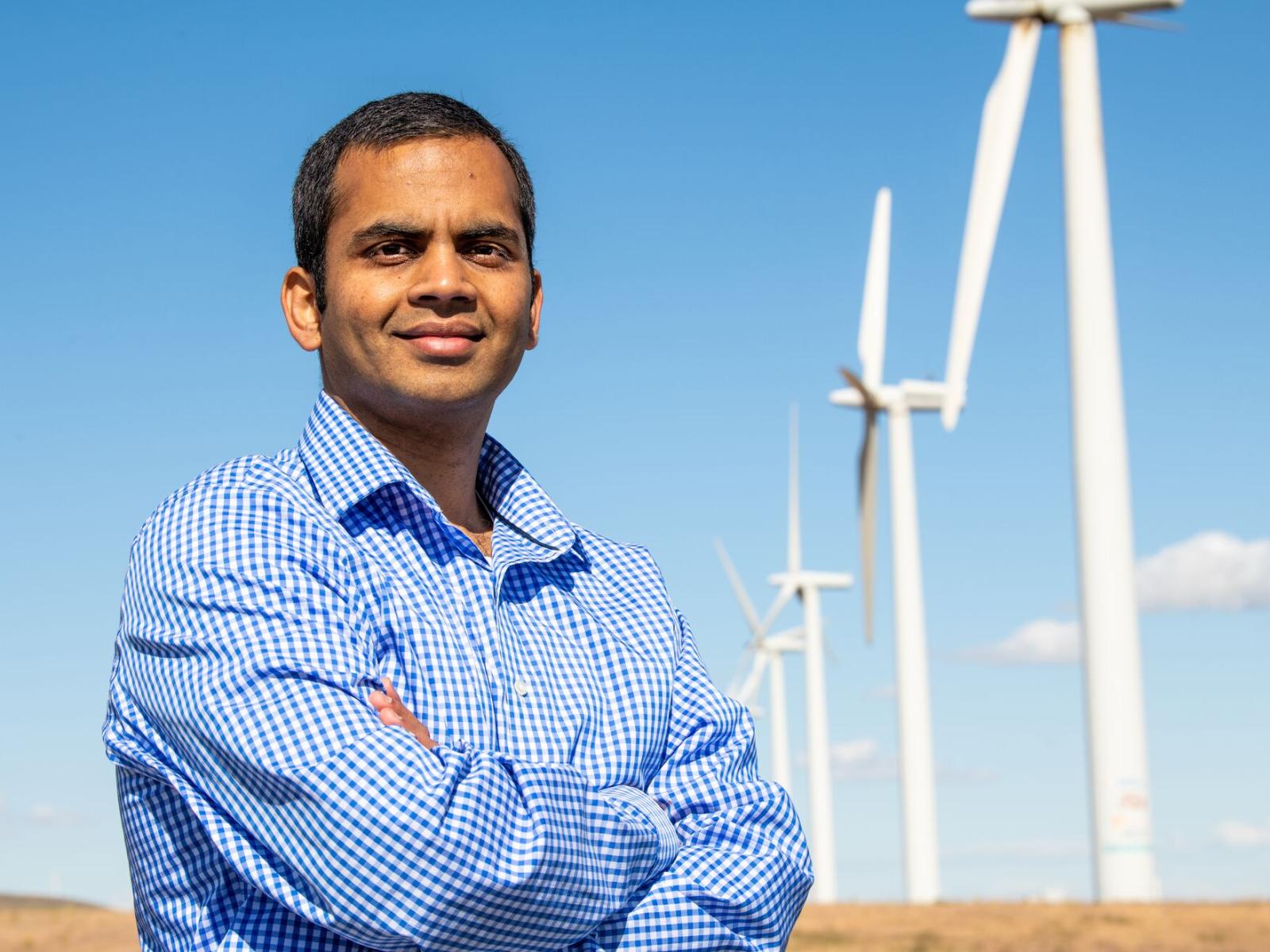 Man standing in front of wind turbines