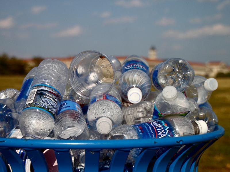 Photograph of empty plastic water bottles heaped in a trash can