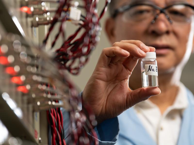 PNNL Researcher Jason Zhang holding up a small, sealed tube.
