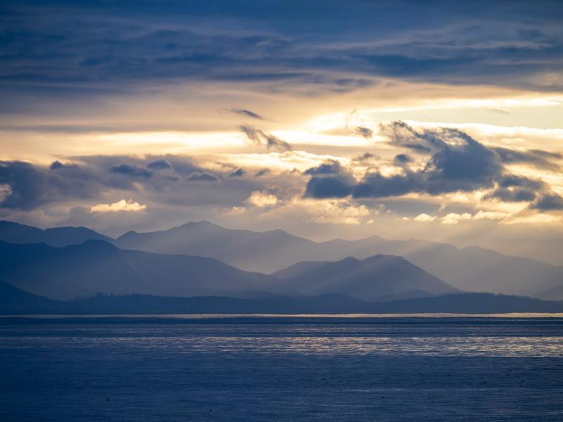 The Salish Sea with mountains in background and cloudy sunset