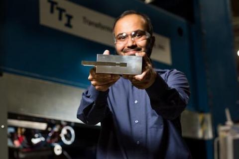 Image of researcher holding a piece of metal
