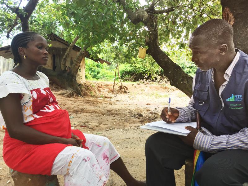 a man interviewing a pregnant woman during an infectious disease screening